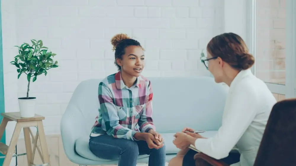 Two women talking in a modern office setting, illustrating setting clear referral expectations